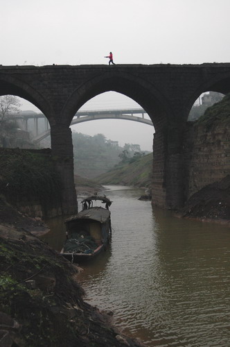     随着三峡水坝水位的上升，前面的老桥将不复存在。